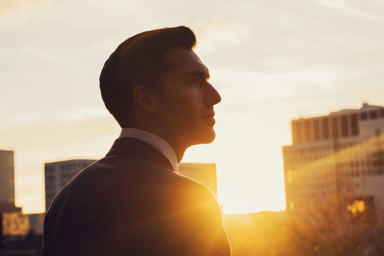 Confident man in a suit at sunset looking in the abyss enjoying the benefits of a life coach