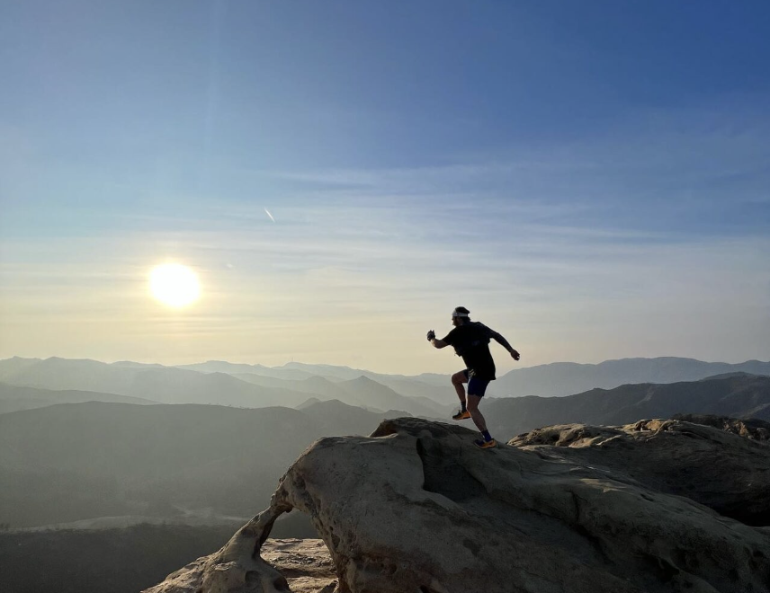 Runner at the top of a cliff showcasing how to be more productive