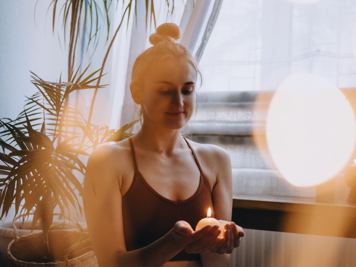 Woman holding a lit candle - Chad Weller